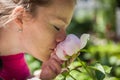 Young beautiful woman enjoying scent of a rose