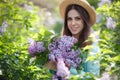 Spring portrait of a beautiful woman outdoors in the park, among the bushes blooming lilac Royalty Free Stock Photo