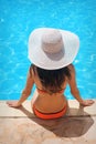 Young beautiful woman enjoying the sun and sitting on edge of the pool Royalty Free Stock Photo