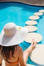 Young beautiful woman enjoying the sun and sitting on edge of the pool Royalty Free Stock Photo