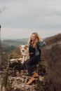 Young beautiful woman enjoying the view with her dog during hiking trip in the mountain Royalty Free Stock Photo