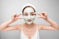 Young beautiful woman in face mask of therapeutic blue mud. Spa treatment, self care and healthy skin. Copy space, white Royalty Free Stock Photo