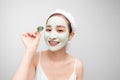 Young beautiful woman in face mask of therapeutic blue mud. Spa treatment, self care and healthy skin. Copy space, white Royalty Free Stock Photo