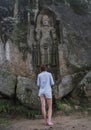 Young beautiful woman facing ancient high holy statue Royalty Free Stock Photo