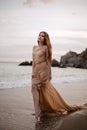 Young beautiful woman fallen angel stands on sea beach enjoy nature. costume bird white wings. Royalty Free Stock Photo