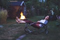 Young beautiful woman fell asleep in rocking chair in the evening garden with a book in her hands Royalty Free Stock Photo