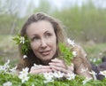 The young beautiful woman in the field of blossoming snowdrops in the early spring Royalty Free Stock Photo