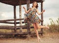 Young beautiful woman in flattering summer floral dress jumping