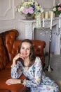 Young beautiful woman in floral dress sits on floor Royalty Free Stock Photo