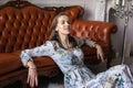 Young beautiful woman in floral dress sits on floor Royalty Free Stock Photo