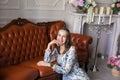 Young beautiful woman in floral dress sits on floor Royalty Free Stock Photo