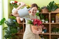 Young beautiful woman florist smiling confident watering plant at flower shop Royalty Free Stock Photo