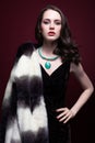 Young beautiful woman in fur coat and with green pistachio colour eyes on red marsala background Royalty Free Stock Photo