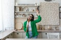 Young beautiful woman in glasses and green shirt in the kitchen having fun Royalty Free Stock Photo