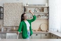 Young beautiful woman in glasses and green shirt in the kitchen having fun Royalty Free Stock Photo