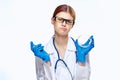 Young beautiful woman in glasses and in medical clothes holds a syringe and a petri dish on a white isolated background Royalty Free Stock Photo