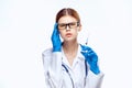 Young beautiful woman in glasses and in medical clothes on white isolated background holds a syringe Royalty Free Stock Photo