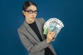 Young beautiful woman in glasses showing a pack of Kazakhstani tenge and Russian rubles in her hand. Selective focus