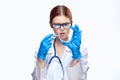 Young beautiful woman with glasses on white background holds a petri dish and syringe, doctor, medicine Royalty Free Stock Photo