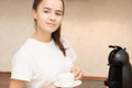 Young beautiful woman is going to make coffee in a coffee machine in the morning in the kitchen, holding a white cup in her hands Royalty Free Stock Photo