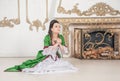 Young beautiful woman in green rococo style medieval dress sitting on the floor and praying Royalty Free Stock Photo