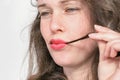 Young beautiful woman with hair strand in red lips. Trichophagia - compulsive eating of hair associated with trichotillomania