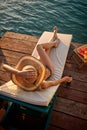 Young beautiful woman with hat, laying on sunbed enjoying her vacation. Fruit platter and drink by her side. Holiday, fun, relax, Royalty Free Stock Photo