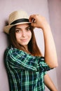 Young woman in hat looking into the camera and smiling