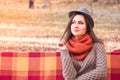 Young beautiful woman in a hat sitting on a bench in an autumn park Royalty Free Stock Photo