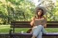 A young woman is sitting on a park bench with the book in her han Royalty Free Stock Photo