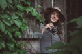 Young beautiful woman in hat is taking picture with old fashioned camera, outdoors Royalty Free Stock Photo