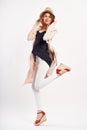 Young beautiful woman in a hat on a white background, full-length, jump, fashion