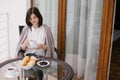 Young beautiful woman having breakfast on a cozy terrace Royalty Free Stock Photo