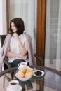 Young beautiful woman having breakfast on a cozy terrace Royalty Free Stock Photo