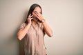 Young beautiful woman having conversation talking on the smartphone over white background tired rubbing nose and eyes feeling Royalty Free Stock Photo