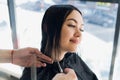 Young beautiful woman having her hair cut at the hairdresser`s. Enjoying the process of making a new hair style. Royalty Free Stock Photo