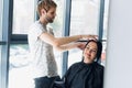 Young beautiful woman having her hair cut at the hairdresser`s. Enjoying the process of making a new hair style. Royalty Free Stock Photo