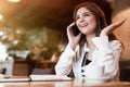 Young beautiful woman having phone conversation working outside office during lunch break drinking hot coffee in cafe modern Royalty Free Stock Photo