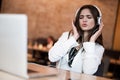 Young beautiful woman in headphones listening her favourite music from laptop singing while waiting her lunch in the cafe happy Royalty Free Stock Photo