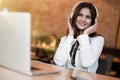 Young beautiful woman in headphones looking happy listening her favourite music from laptop while waiting her lunch in the cafe