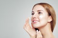 Young beautiful woman with healthy clear skin applying moisturizing cream on her face. Female face closeup Royalty Free Stock Photo