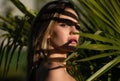 Young beautiful woman with healthy skin of face and palm leaves. Closeup fresh face of attractive girl. Summer model Royalty Free Stock Photo