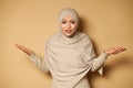 Young beautiful woman in hijab looks at the camera expressing bewilderment, surprise and confusion. Stylish beautiful traditional