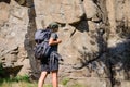 Young Beautiful Woman Hiker with Big Backpack on the Rock Background. Adventure and Travel Concept