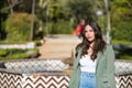 Young and beautiful woman, Hispanic, brown hair, with green jacket and jeans, looking at the camera serious and relaxed. Concept Royalty Free Stock Photo