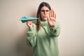 Young beautiful woman holding airplane of paper standing over isolated grey background with open hand doing stop sign with serious Royalty Free Stock Photo