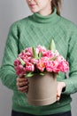 Young beautiful woman holding a bouquet of tulips in a gift box. pink colors in one box or bouquet. Present on March 8 Royalty Free Stock Photo