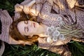 Young Beautiful Woman Holding Bunch Of Dandelion Flowers Lying On Green Grass. Top View. Royalty Free Stock Photo