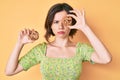 Young beautiful woman holding cookies skeptic and nervous, frowning upset because of problem