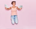 Young beautiful woman holding dollars banknotes smiling happy Royalty Free Stock Photo